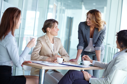 Image of four businesswomen interacting at meeting <script srcset=